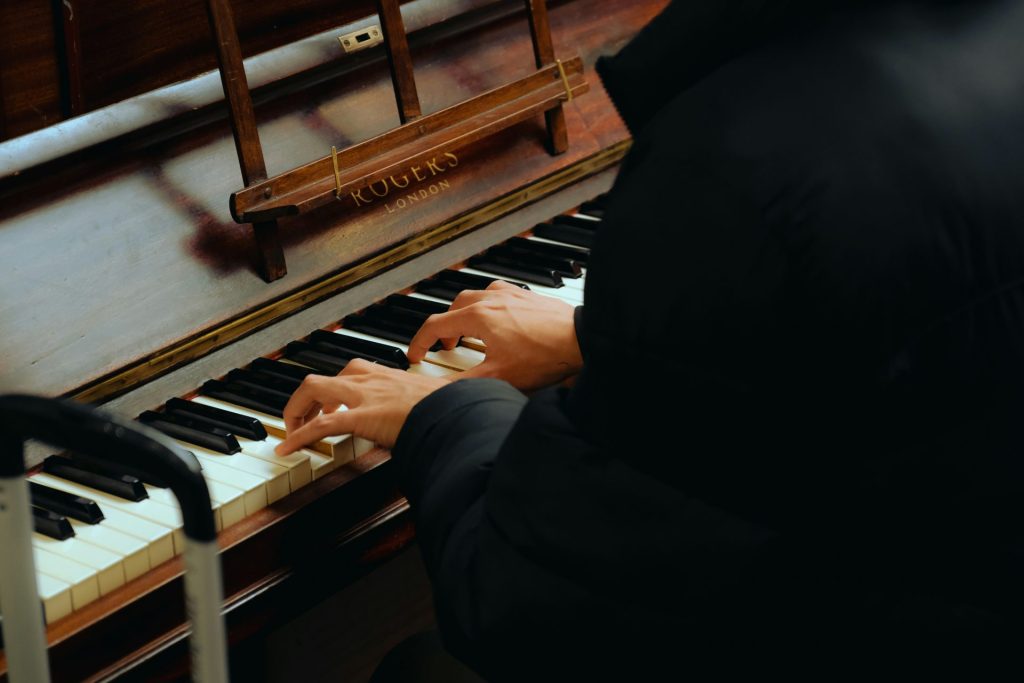 a person sitting at a piano playing a musical instrument